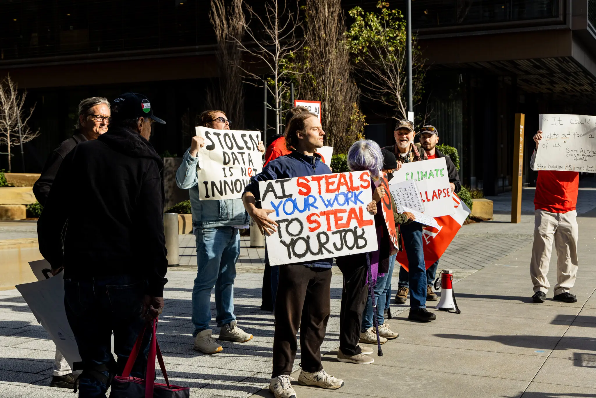 People holding signs while protesting artificial intelligence in San Francisco.